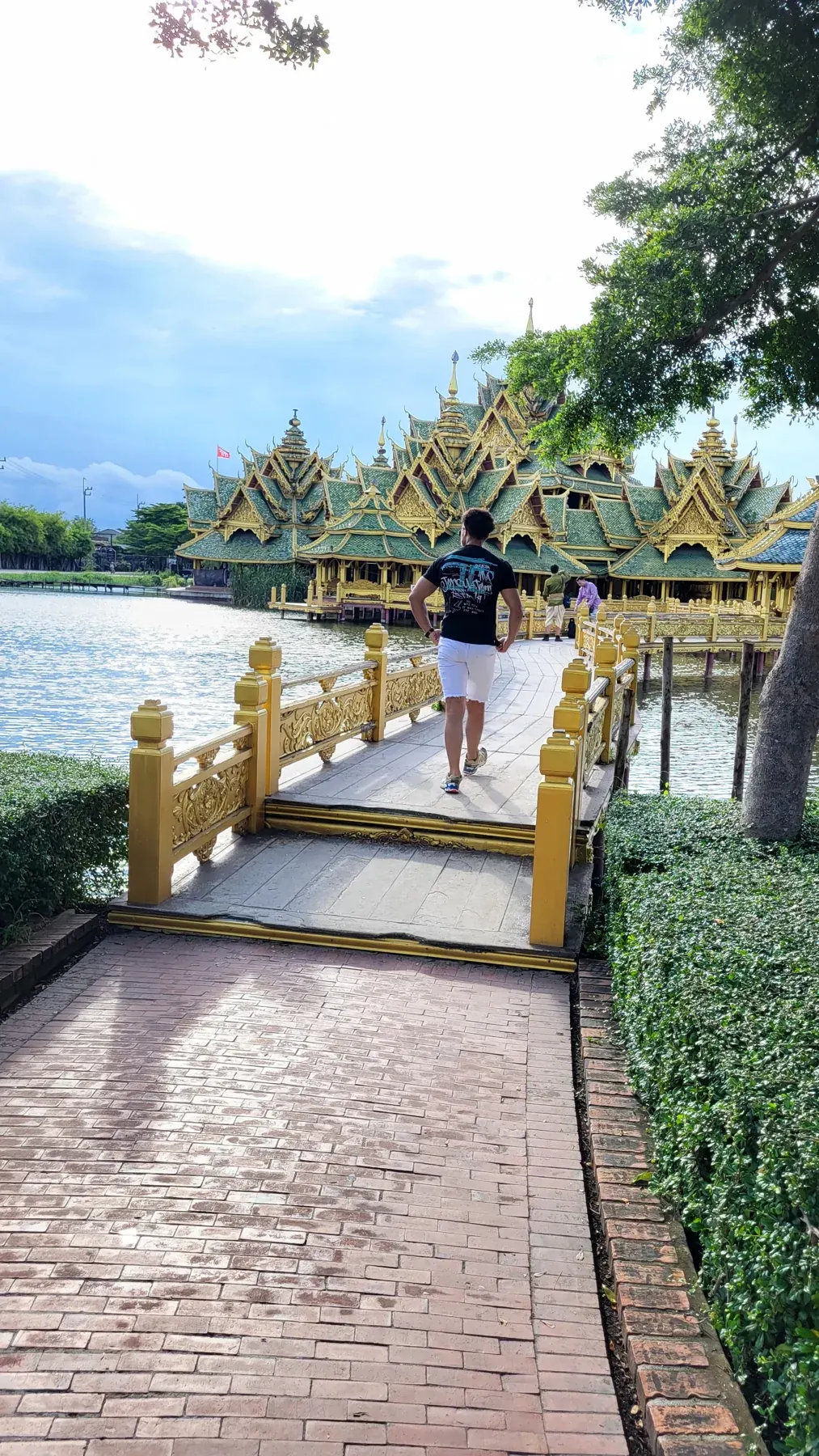 Dainyel walking towards an ornate temple in Thailand