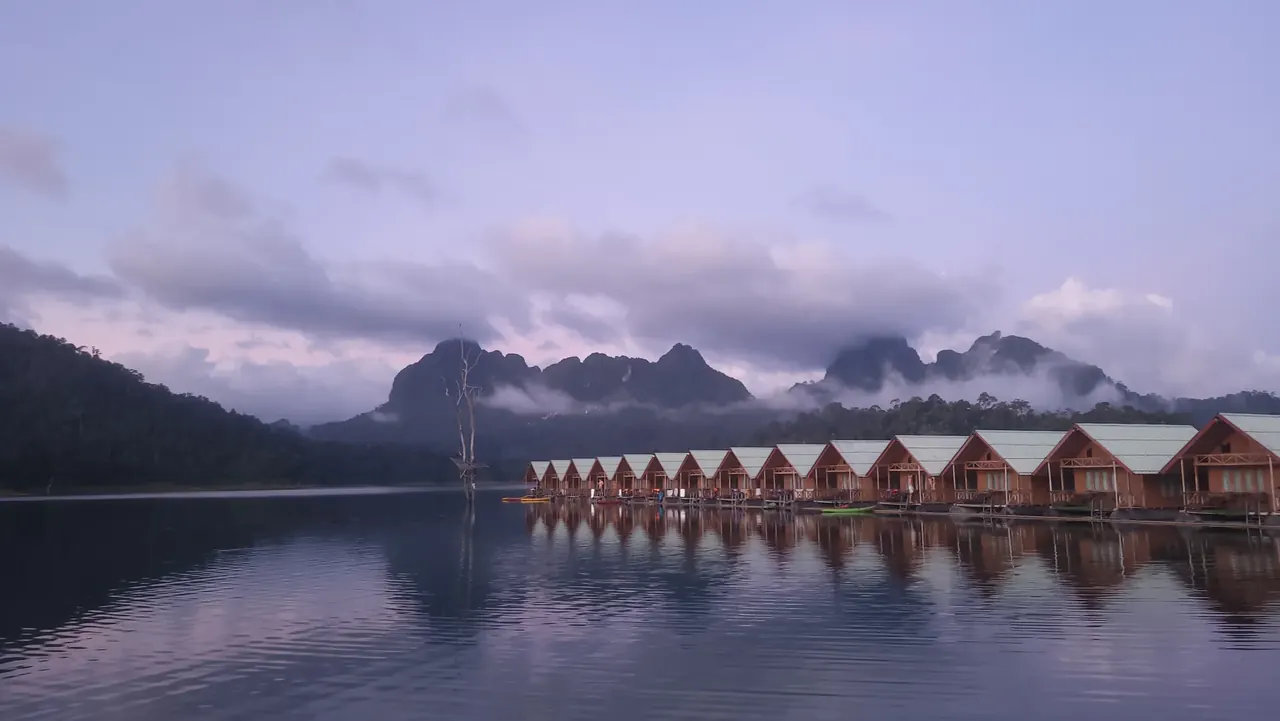 Floating lodges on a still lake beneath misty mountains in Khao Sok