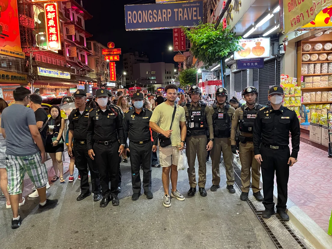 Dainyel posing with police officers on a Bangkok street