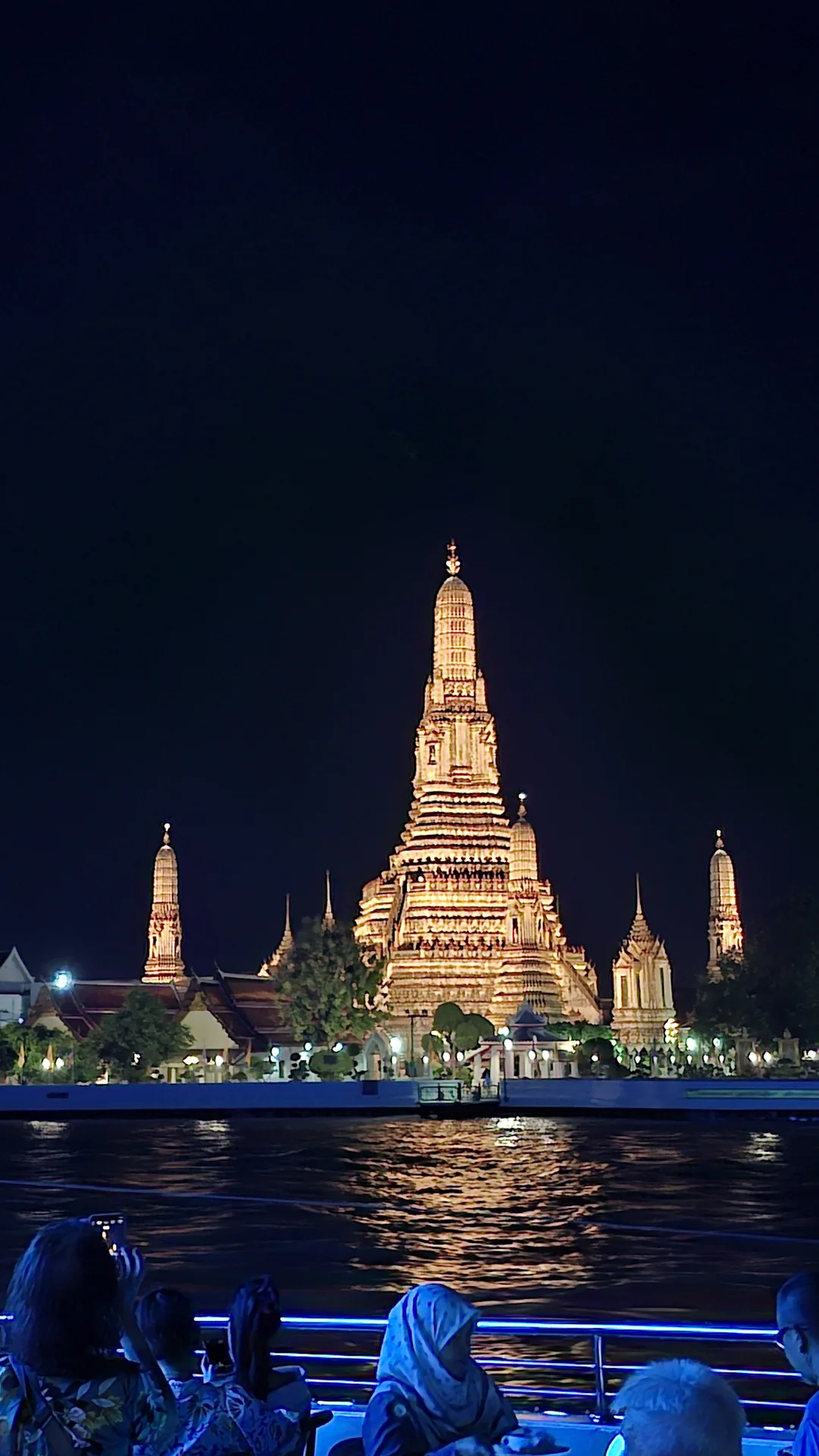 Wat Arun illuminated across the river at night