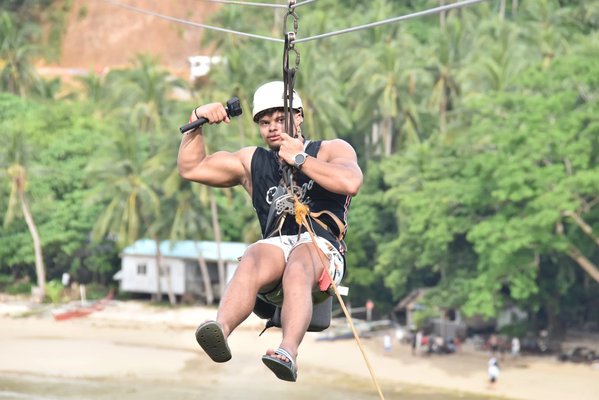 Dainyel ziplining above a tropical beach